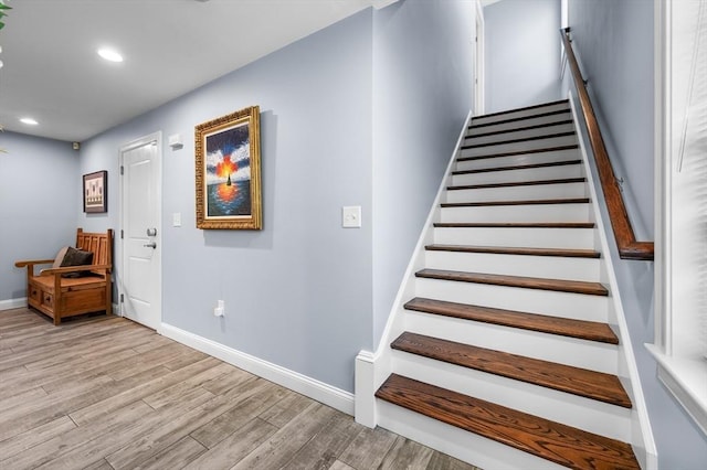 stairway featuring wood finished floors, baseboards, and recessed lighting