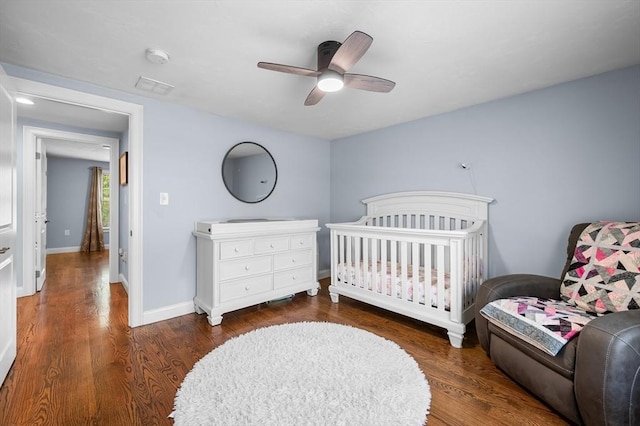 bedroom with baseboards, visible vents, ceiling fan, and wood finished floors