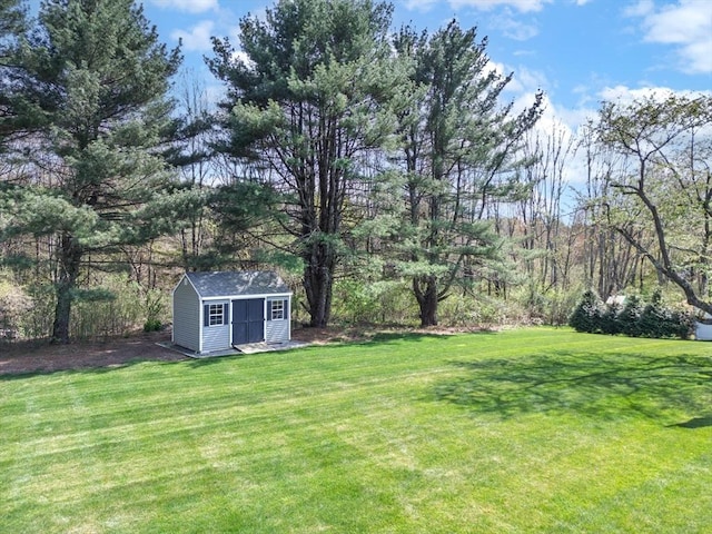 view of green lawn with a storage unit and an outbuilding