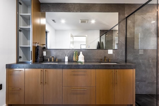 bathroom featuring vanity, decorative backsplash, and a shower with door