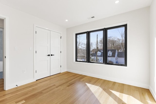 unfurnished bedroom featuring wood-type flooring and a closet