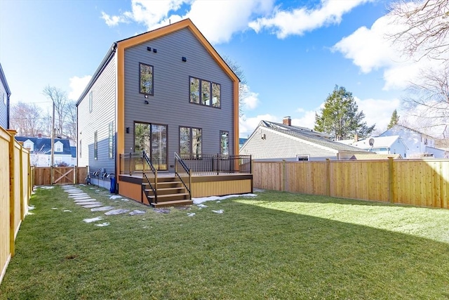 rear view of house featuring a lawn and a deck