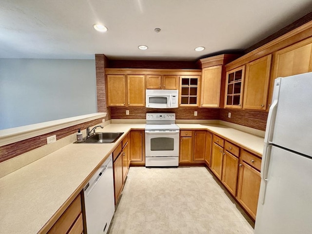 kitchen with recessed lighting, a sink, white appliances, glass insert cabinets, and tasteful backsplash