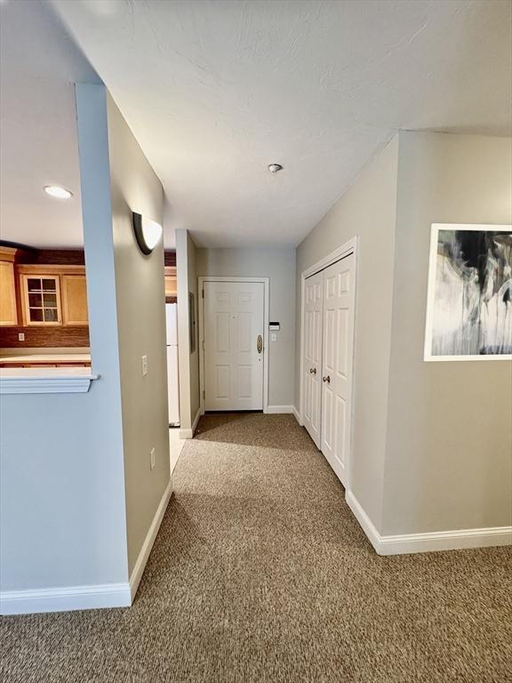 hallway with recessed lighting, carpet flooring, and baseboards