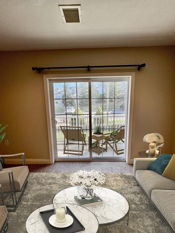 carpeted living room featuring baseboards and visible vents