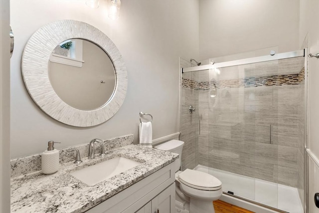 full bathroom with a shower stall, toilet, and vanity