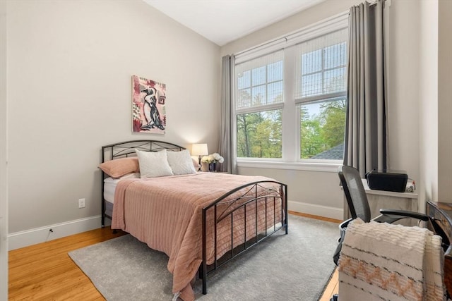 bedroom featuring baseboards and wood finished floors