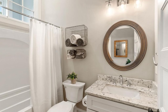 bathroom featuring vanity, toilet, and shower / bath combo with shower curtain