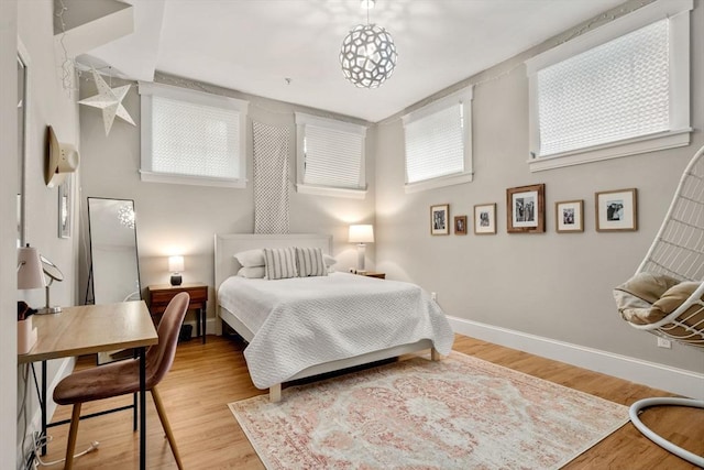 bedroom with baseboards and wood finished floors