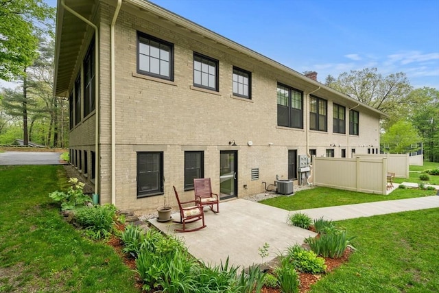 rear view of house with a patio area, brick siding, a chimney, and cooling unit