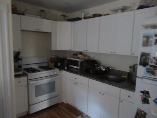 kitchen featuring sink, white cabinets, white gas range, and dark hardwood / wood-style flooring