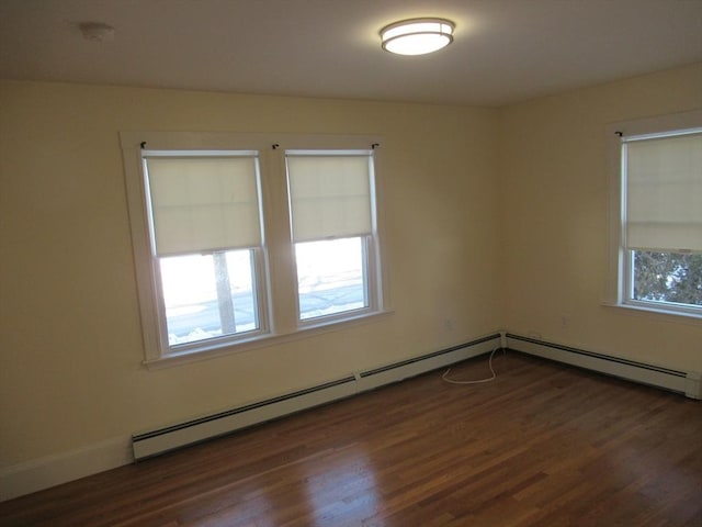 spare room with a baseboard radiator and dark wood-type flooring