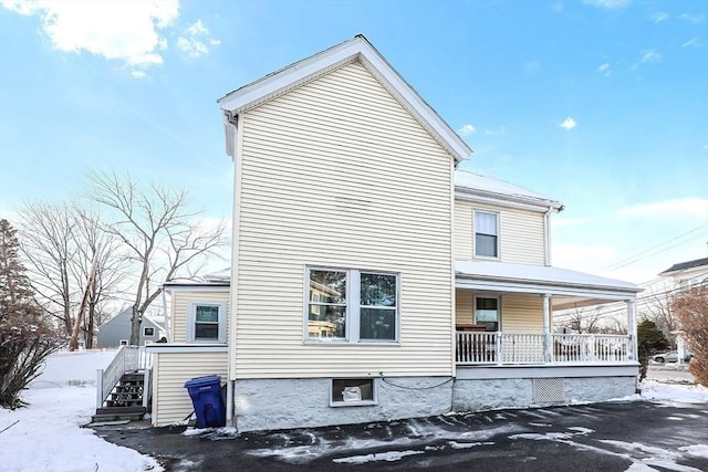 view of snowy exterior featuring a porch