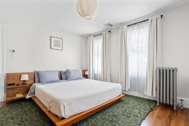 149-151 Pleasant St, Watertown, MA 02472 - bedroom featuring radiator heating unit and wood finished floors