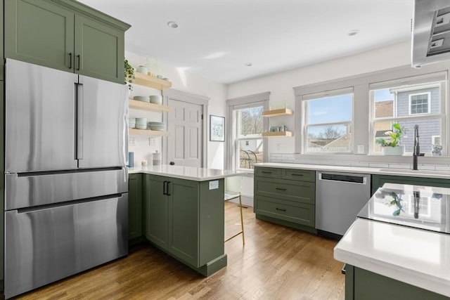 149-151 Pleasant St, Watertown, MA 02472 - kitchen featuring green cabinets, appliances with stainless steel finishes, open shelves, a sink, and light countertops