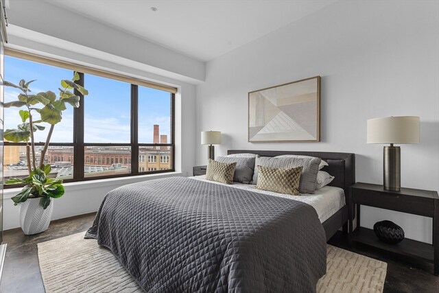 bedroom with multiple windows and concrete flooring