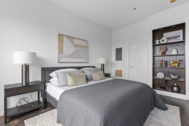 bedroom with electric panel and dark wood-type flooring