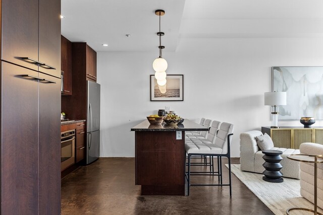 kitchen featuring a kitchen breakfast bar, hanging light fixtures, and appliances with stainless steel finishes