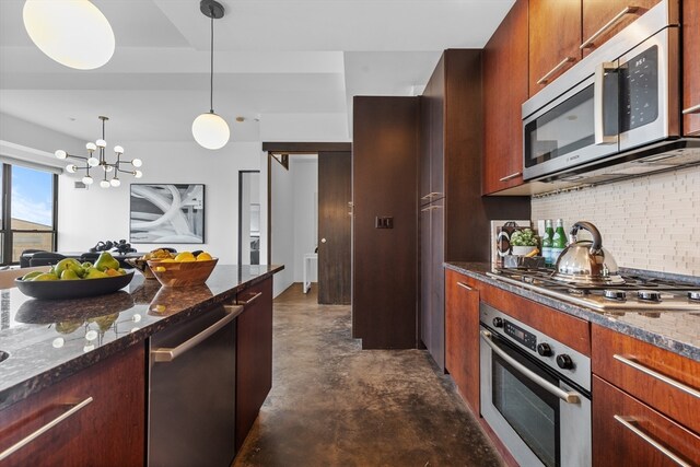 kitchen featuring decorative backsplash, dark stone counters, decorative light fixtures, a chandelier, and appliances with stainless steel finishes