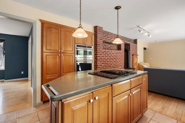 kitchen with light tile patterned flooring, a kitchen island, stainless steel double oven, black electric cooktop, and hanging light fixtures