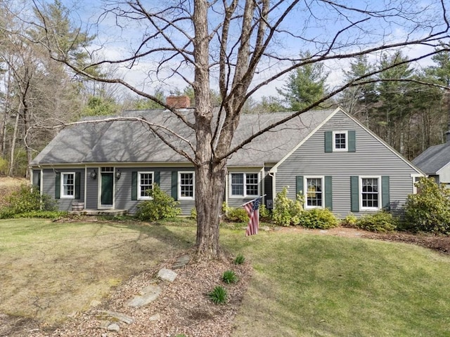 view of front facade with a chimney and a front yard