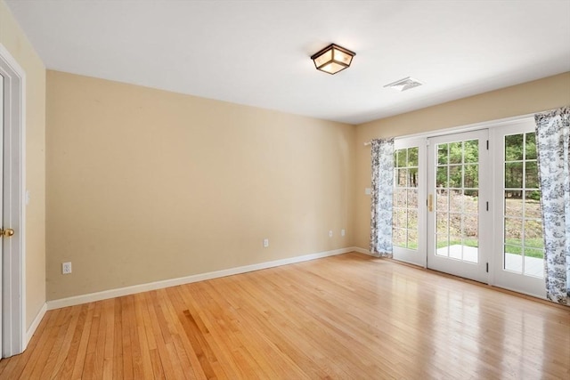 unfurnished room with light wood-style floors, baseboards, and visible vents
