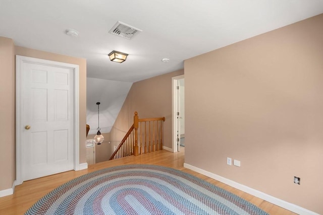bonus room featuring baseboards, wood finished floors, and visible vents
