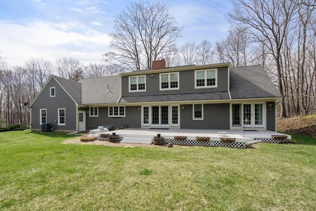 rear view of house with central air condition unit, a lawn, a chimney, and a wooden deck