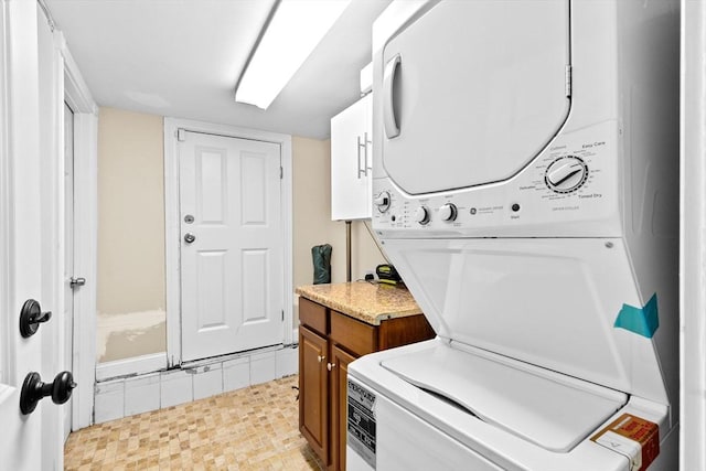 13 Emmet St Unit 1, Boston, MA 02127 - laundry area featuring stacked washer and clothes dryer and cabinet space