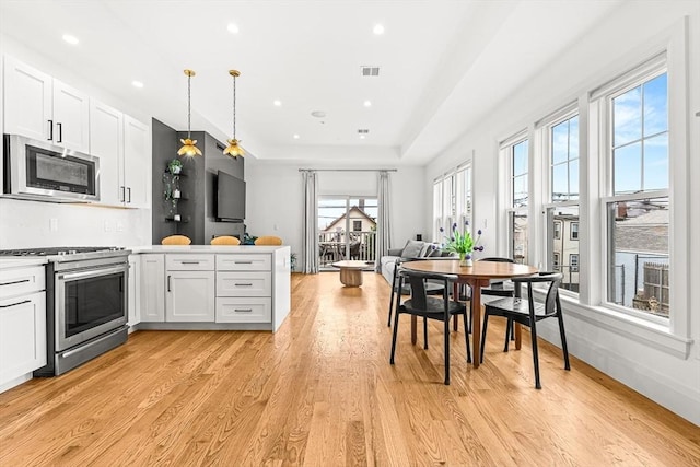 239 Lexington St Unit 2, Boston, MA 02128 - dining space with light wood-type flooring, recessed lighting, and a tray ceiling
