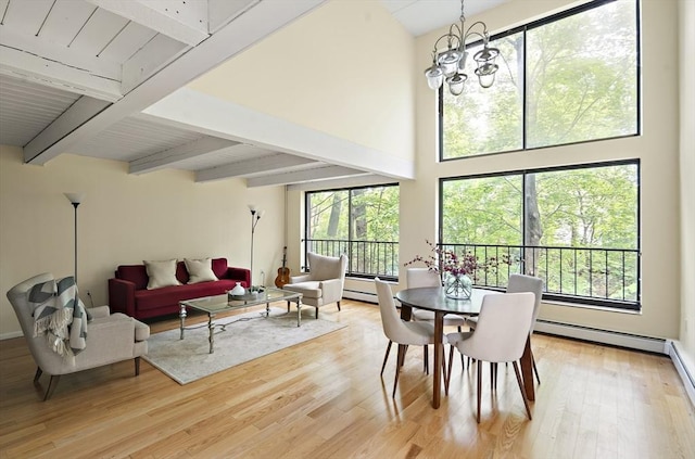 993 Massachusetts Ave Unit 127, Arlington, MA 02476 - dining space with light wood finished floors, beam ceiling, a chandelier, a high ceiling, and a baseboard radiator