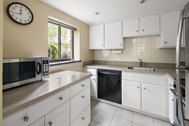993 Massachusetts Ave Unit 127, Arlington, MA 02476 - kitchen with appliances with stainless steel finishes, a sink, decorative backsplash, light tile patterned floors, and light countertops