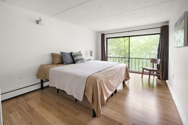 993 Massachusetts Ave Unit 127, Arlington, MA 02476 - bedroom with a baseboard radiator and light wood finished floors