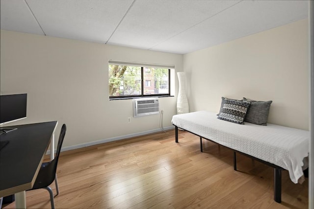 993 Massachusetts Ave Unit 127, Arlington, MA 02476 - bedroom featuring wood finished floors, baseboards, and a wall mounted AC