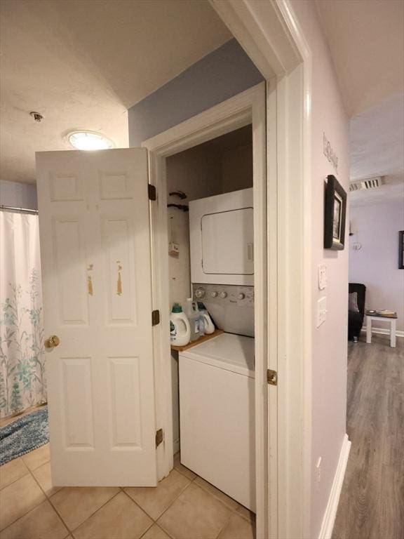 234 Water St Unit 101, Wakefield, MA 01880 - laundry room with stacked washer / dryer and light tile patterned flooring