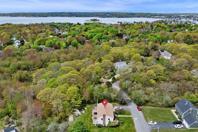aerial overview of property's location with a nearby body of water and a forest