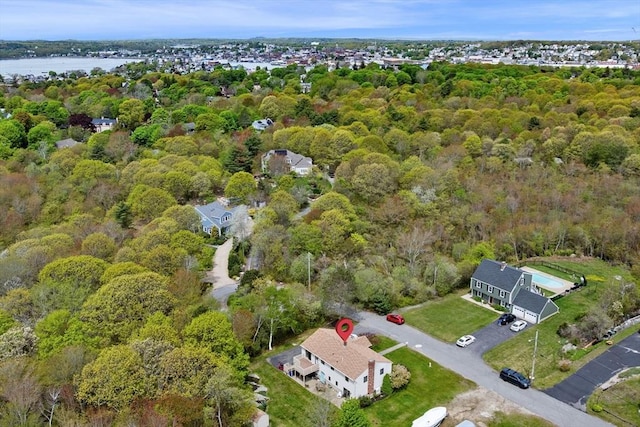 aerial view of property's location featuring a heavily wooded area and a nearby body of water