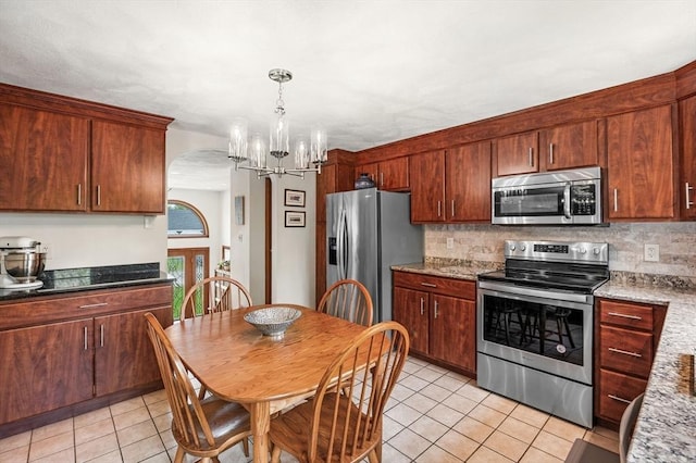 kitchen featuring stainless steel appliances, light tile patterned floors, a chandelier, and tasteful backsplash