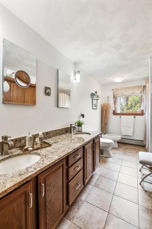 full bath featuring toilet, double vanity, a textured ceiling, tile patterned floors, and a bidet