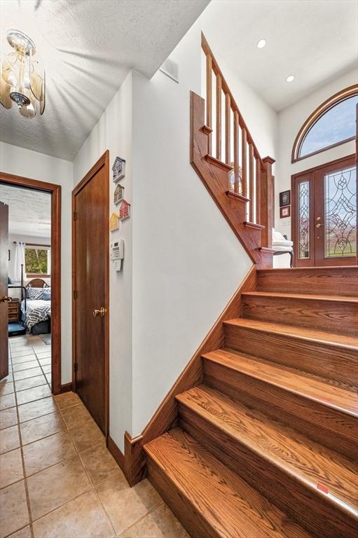 foyer entrance featuring stairway, a chandelier, light tile patterned flooring, recessed lighting, and baseboards