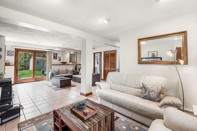 living room with light tile patterned floors and a wood stove
