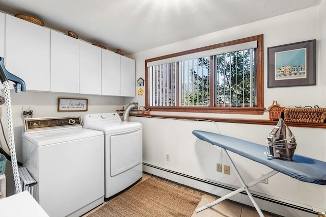 washroom with baseboard heating, washing machine and dryer, and cabinet space
