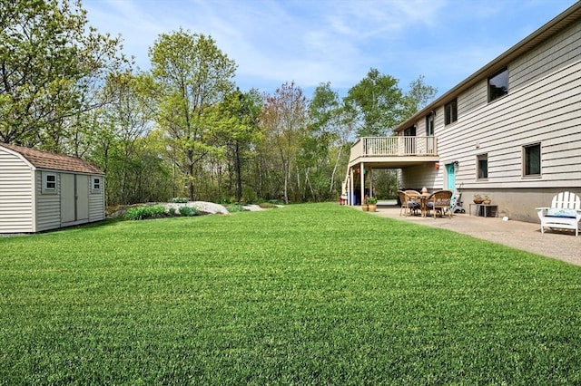 view of grassy yard with a storage shed, a patio, an outdoor structure, and a deck