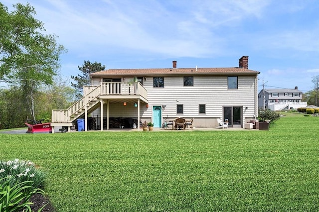 back of house featuring stairs, a wooden deck, a chimney, a yard, and a patio