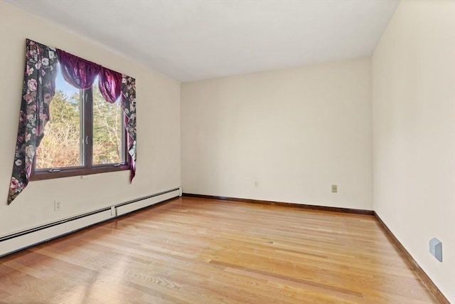 empty room featuring light wood-style floors, baseboards, and baseboard heating
