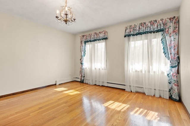 empty room with light wood-style floors, baseboards, a notable chandelier, and baseboard heating