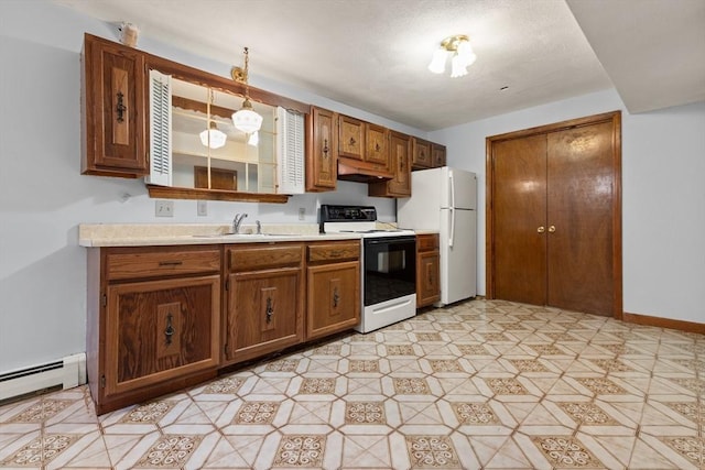 kitchen with range with electric stovetop, a sink, light countertops, a baseboard radiator, and freestanding refrigerator