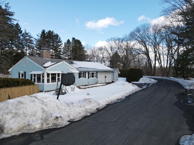 view of front of home with fence, a sunroom, and a chimney