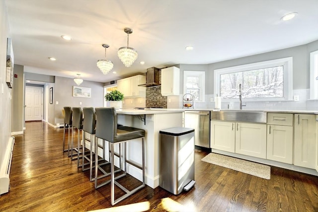 kitchen with sink, wall chimney range hood, dishwasher, backsplash, and hanging light fixtures