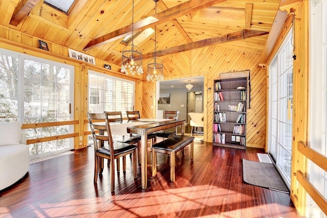 dining space featuring hardwood / wood-style flooring, wood ceiling, vaulted ceiling with skylight, and a chandelier